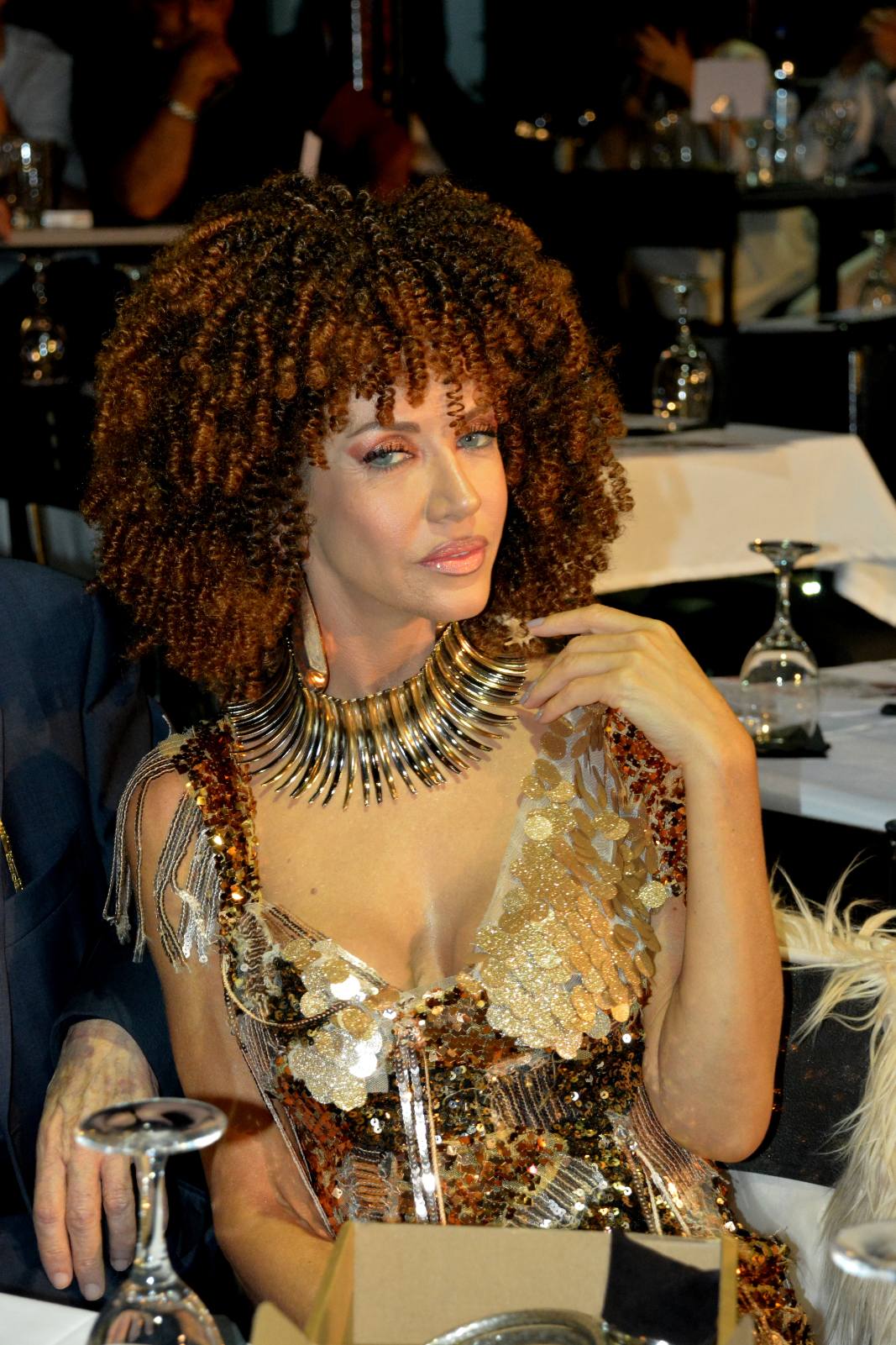 Copper curls with a golden collar and sequinned gown