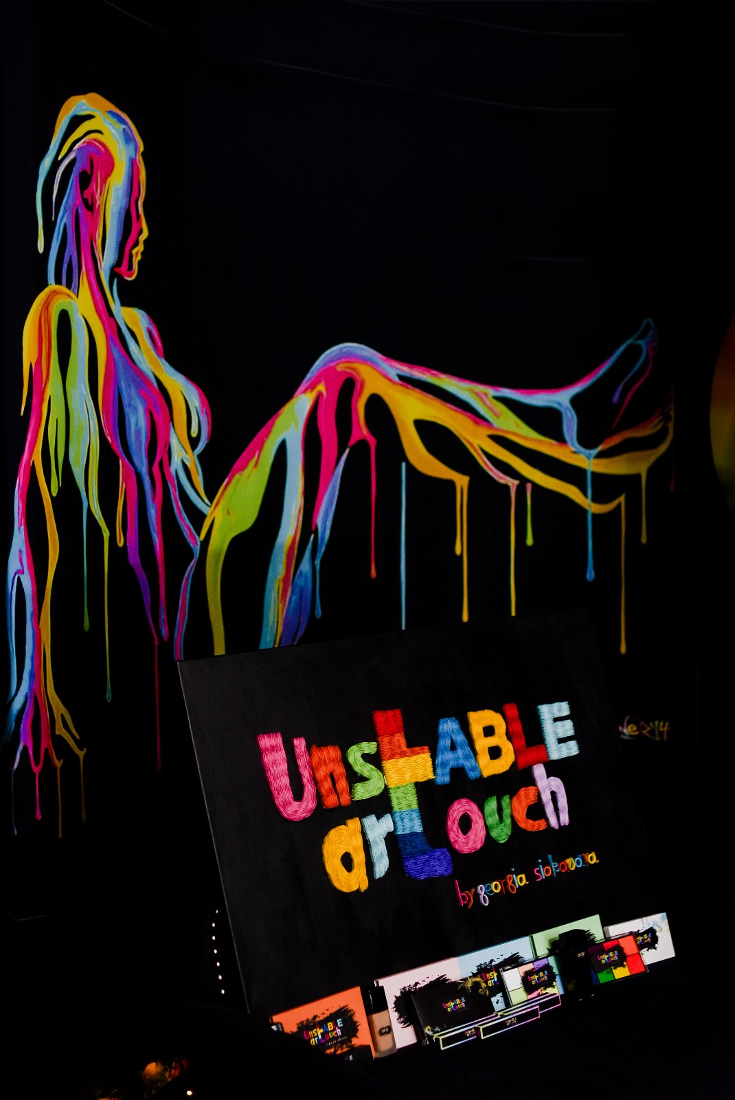 Dripping neon muse painting behind the UNSTABLE ARTOUCH sign