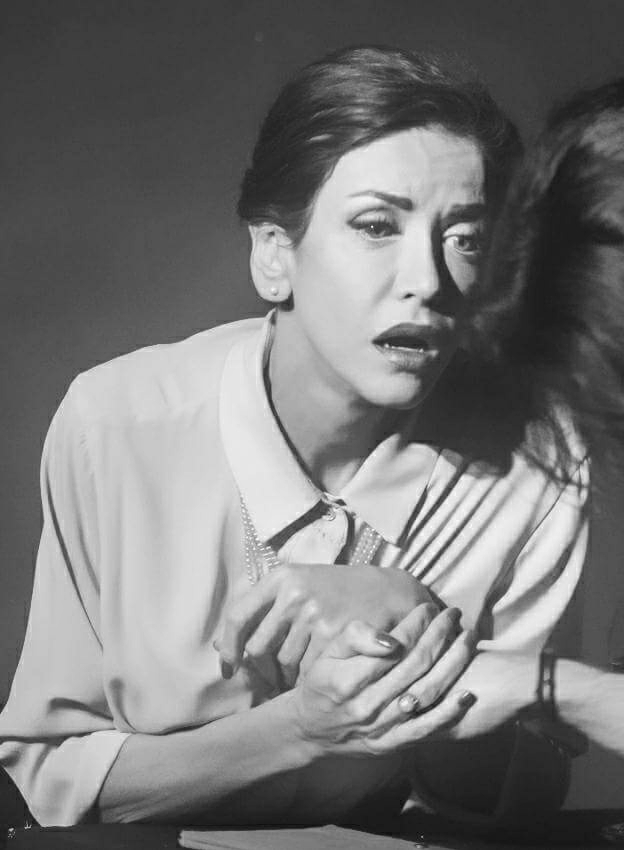 Black and white theatre portrait in a pearl-collar blouse