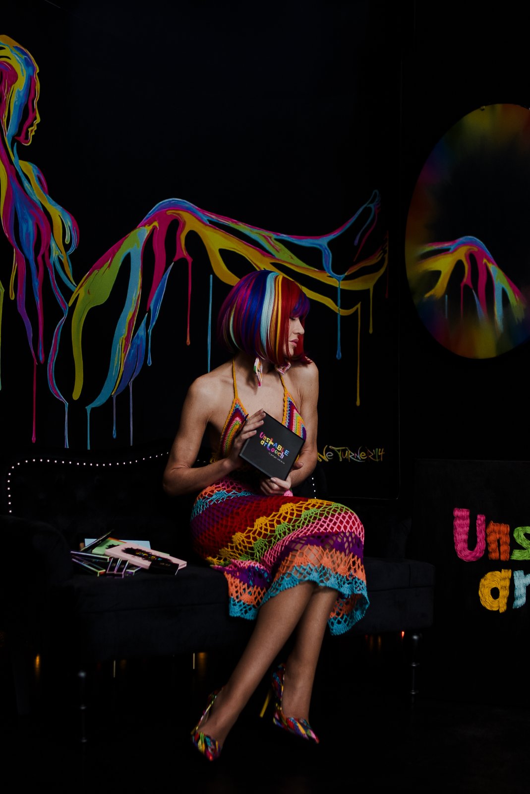 Holding the UNSTABLE ARTOUCH palette on the black sofa